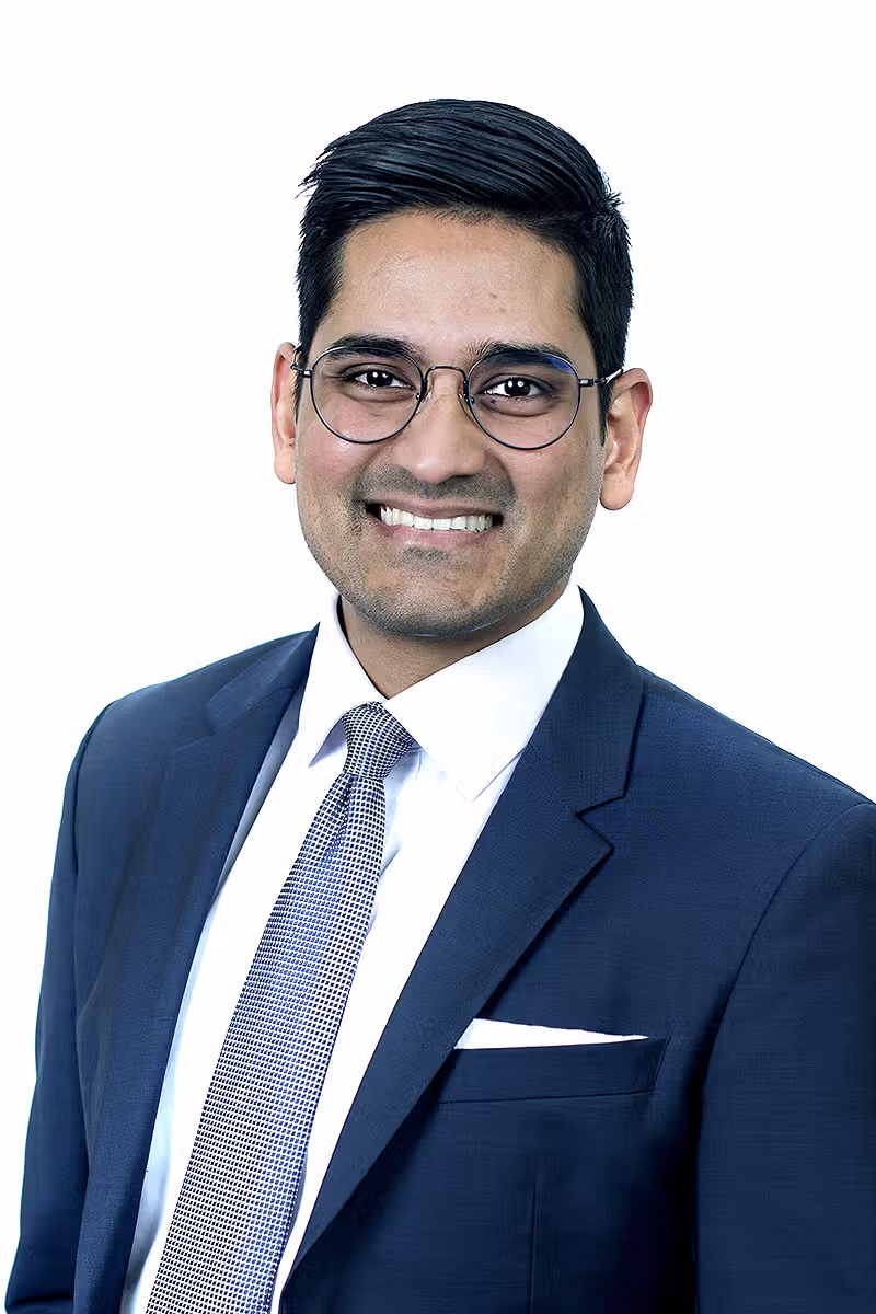 Professional headshot of a business person wearing glasses on a white background