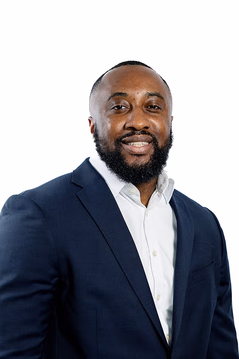 Corporate headshot of a professional in a navy suit on a white background