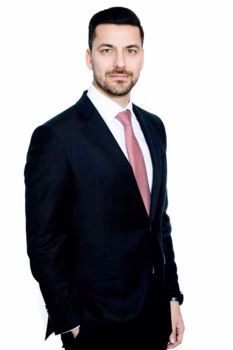 Executive business portrait of a professional in a suit with red tie on a white background