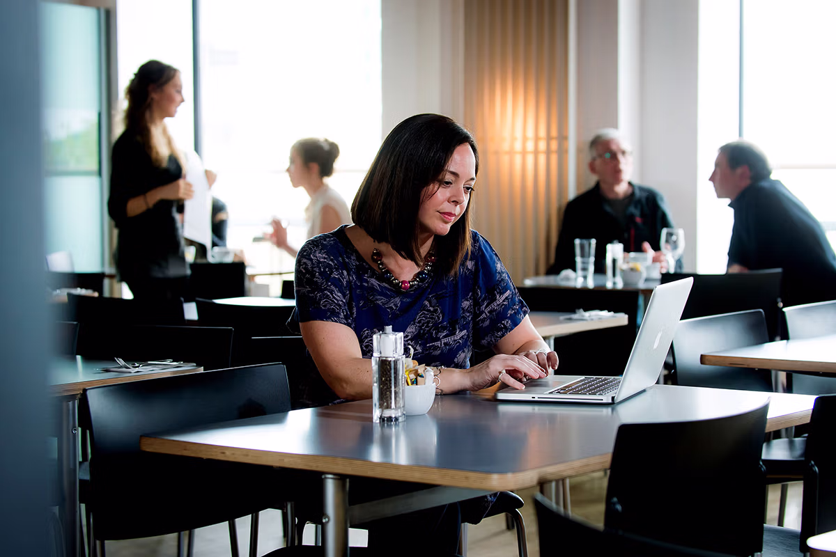 Corporate photography of people in an office environment during a laptop meeting