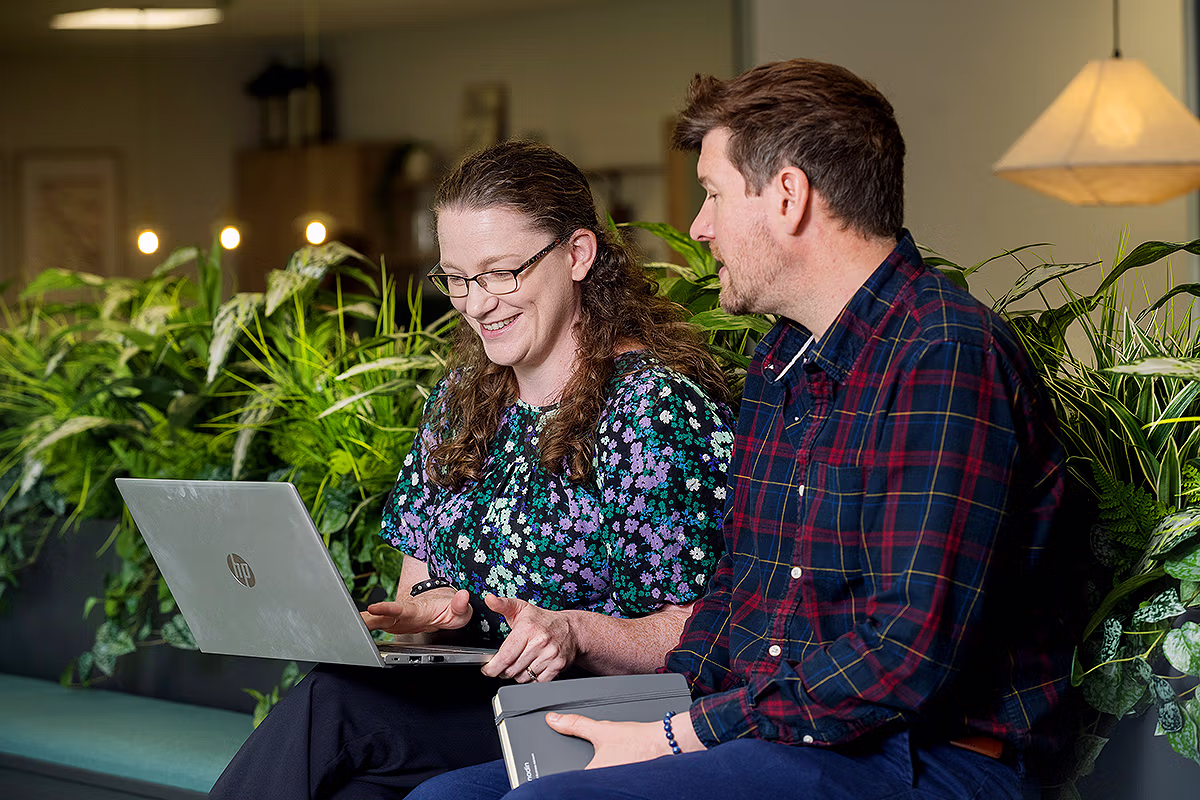 People collaborating around a laptop in a modern office environment