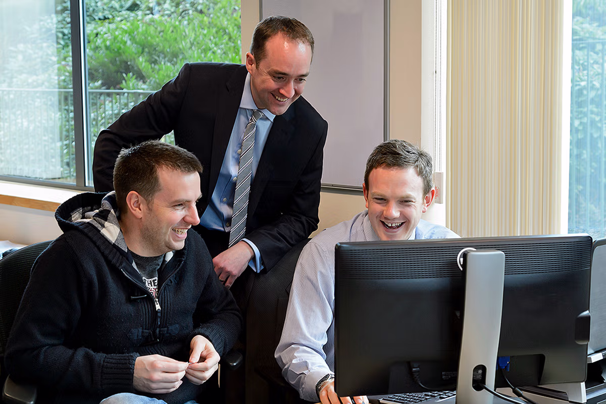 Office culture photography of a team working together at a computer