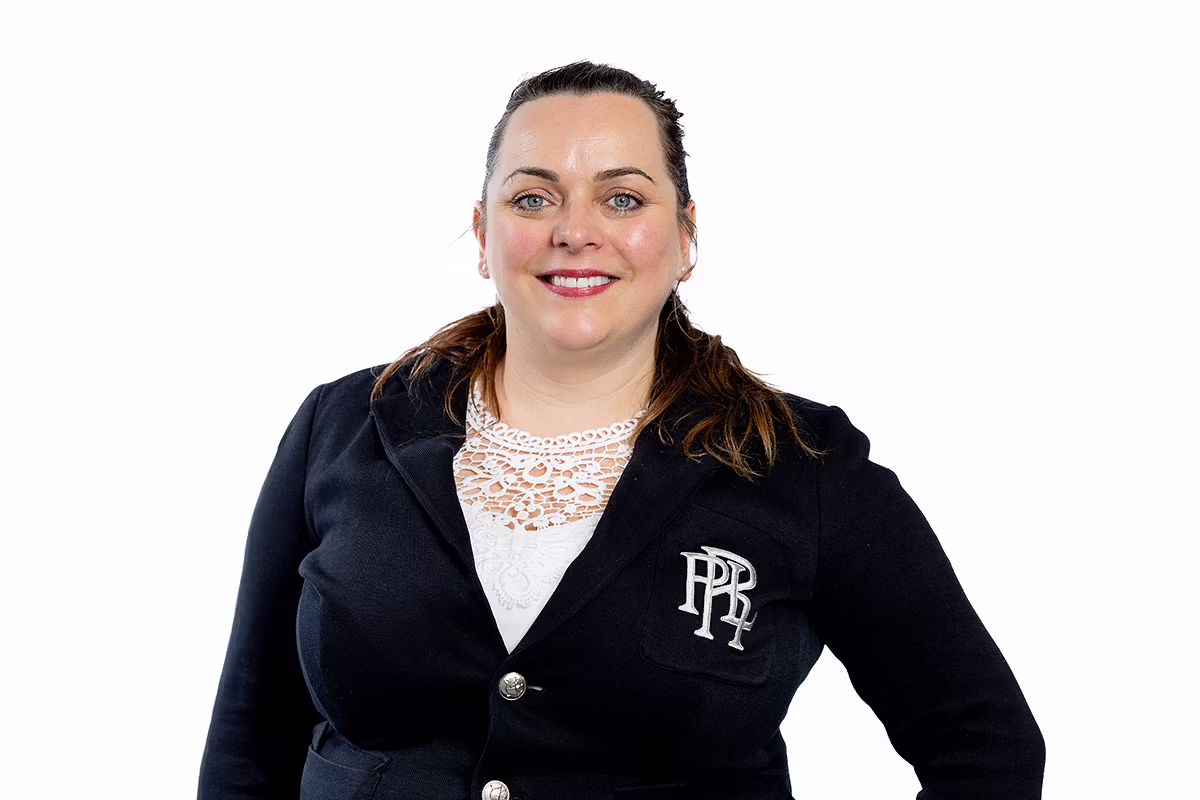 Corporate headshot of a woman in a blazer on a white background for business profile use