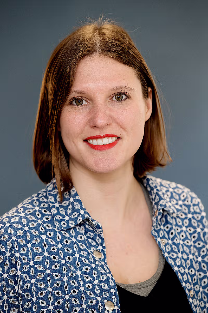 Executive portrait of a woman against a grey background for professional corporate profile use