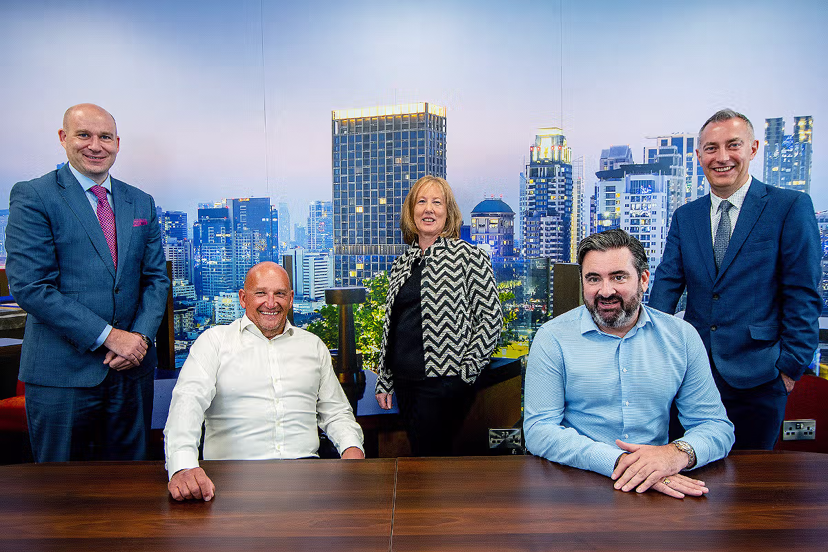 Leadership team portrait in a London boardroom with city skyline views for corporate communications
