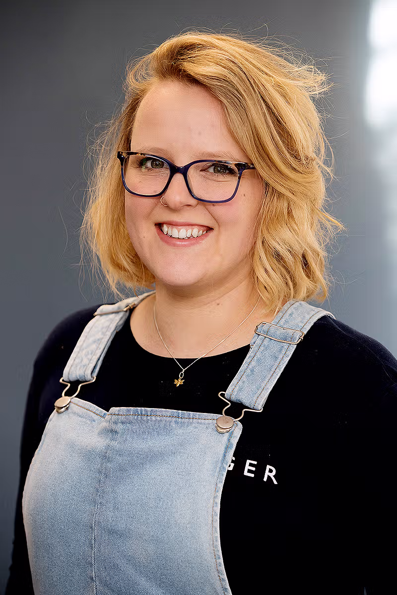 Office profile portrait of a woman with glasses for corporate communications and staff profile use