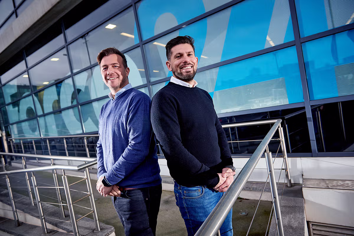 Two-person leadership portrait outside a modern London office building