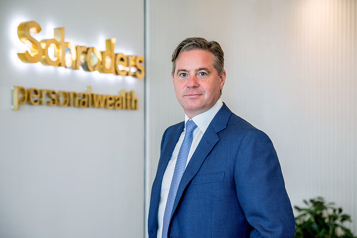 Mark Duckworth portrait at Schroders Personal Wealth with illuminated company branding behind him at London Wall Place