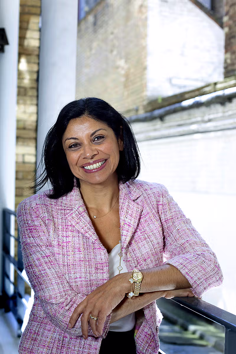 Professional portrait of a woman leaning on a railing outside a London building