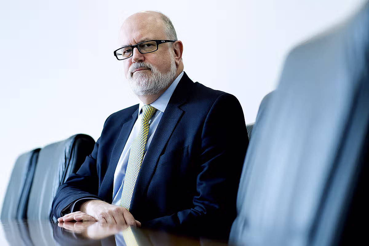 Executive portrait of a businessman seated in a boardroom with window light