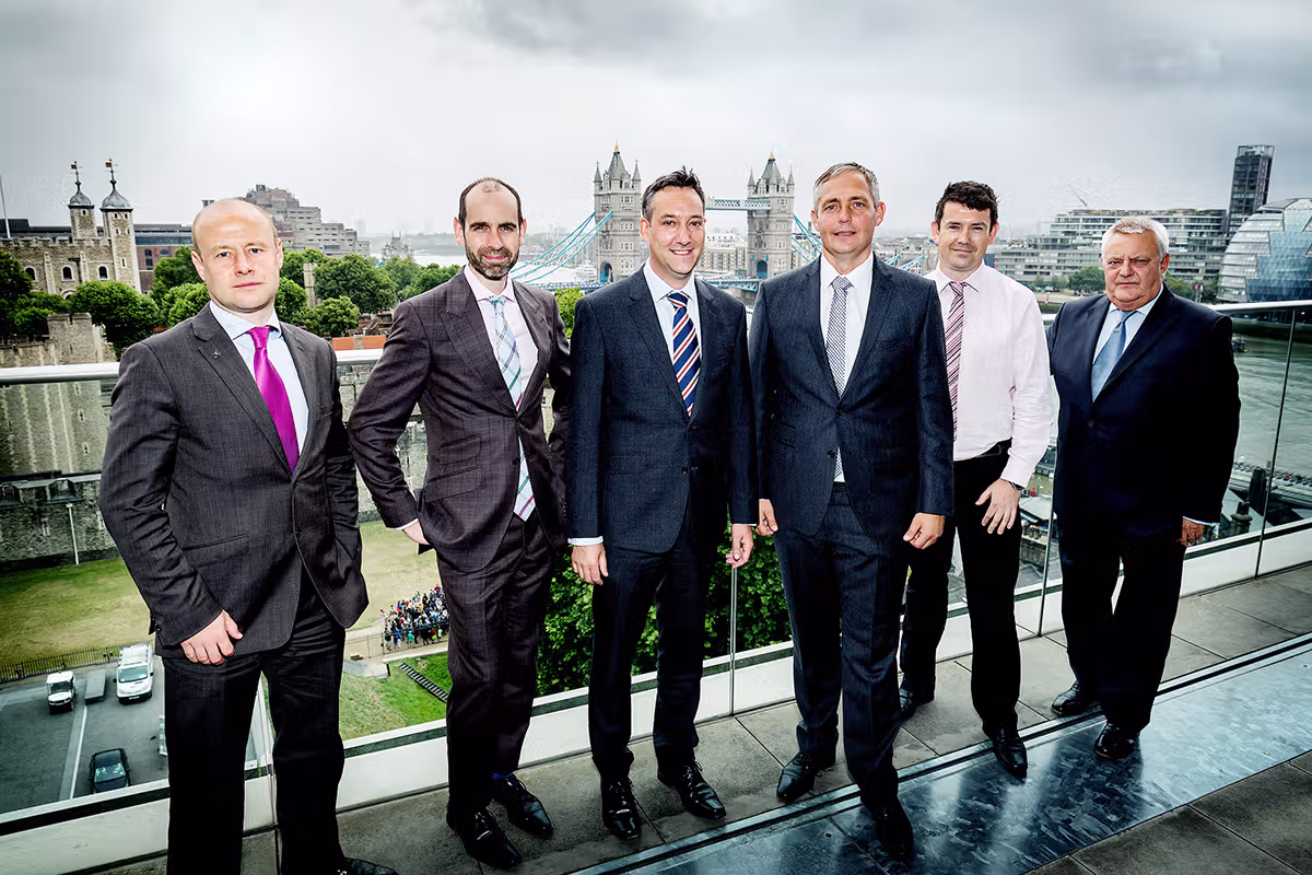 Business group portrait on a London rooftop terrace with skyline behind