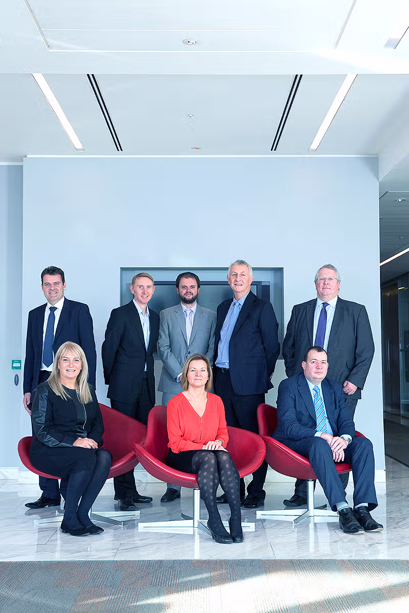 Corporate group portrait of senior business team members in a modern London office