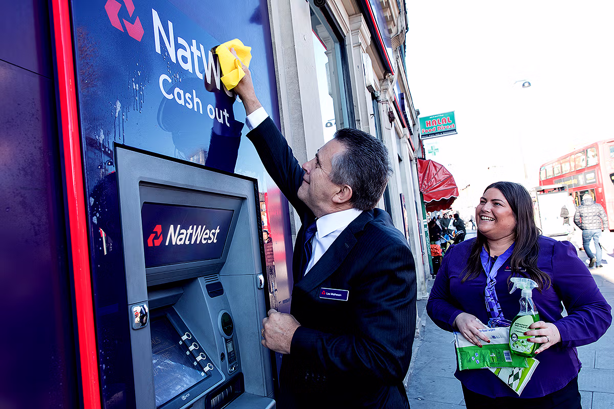 Les Matheson helping open and clean the cash machine at NatWest Wood Green branch for a London PR and press story