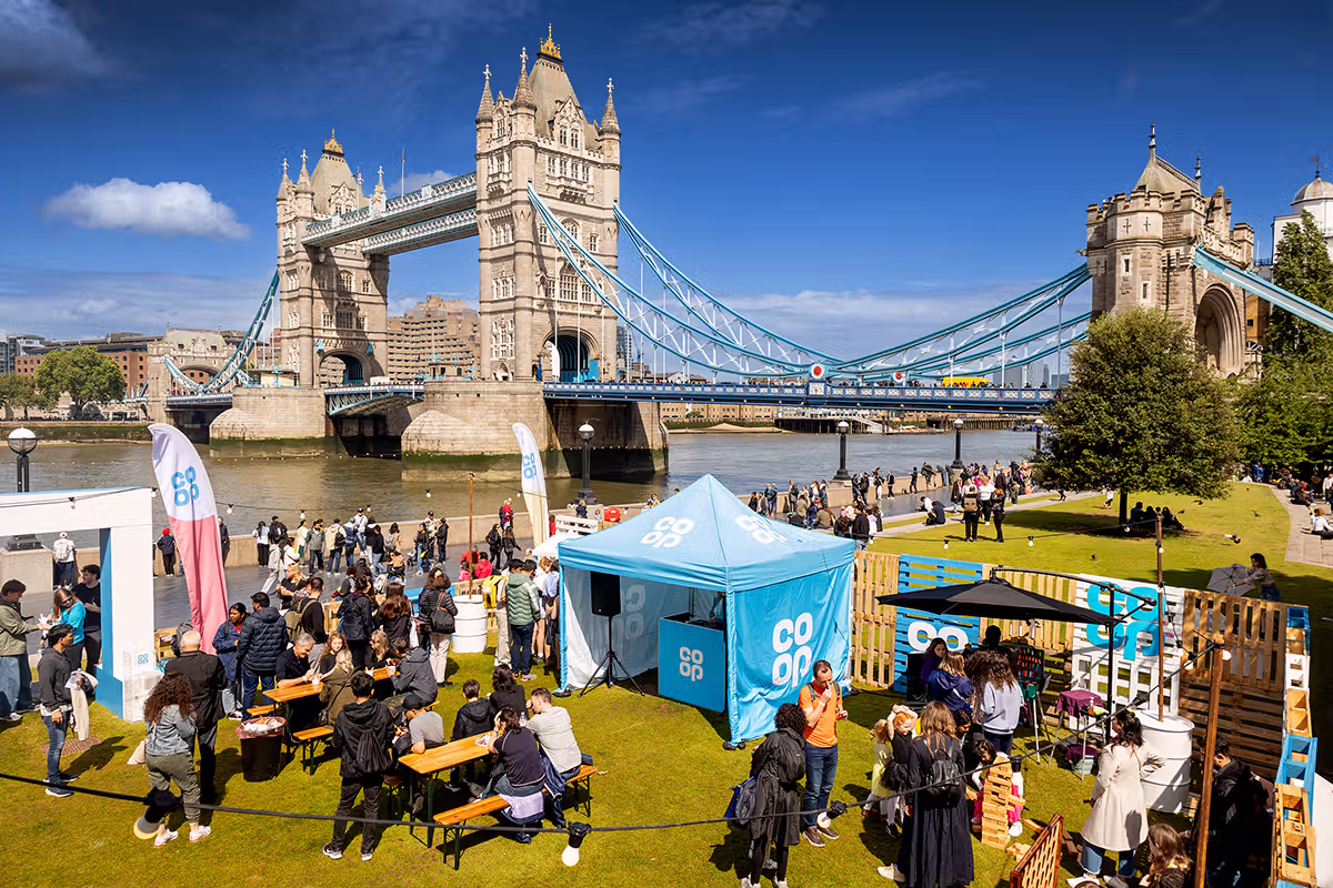 Wide London PR event photograph showing the Co-op Food Festival village below Tower Bridge at Potters Fields Park