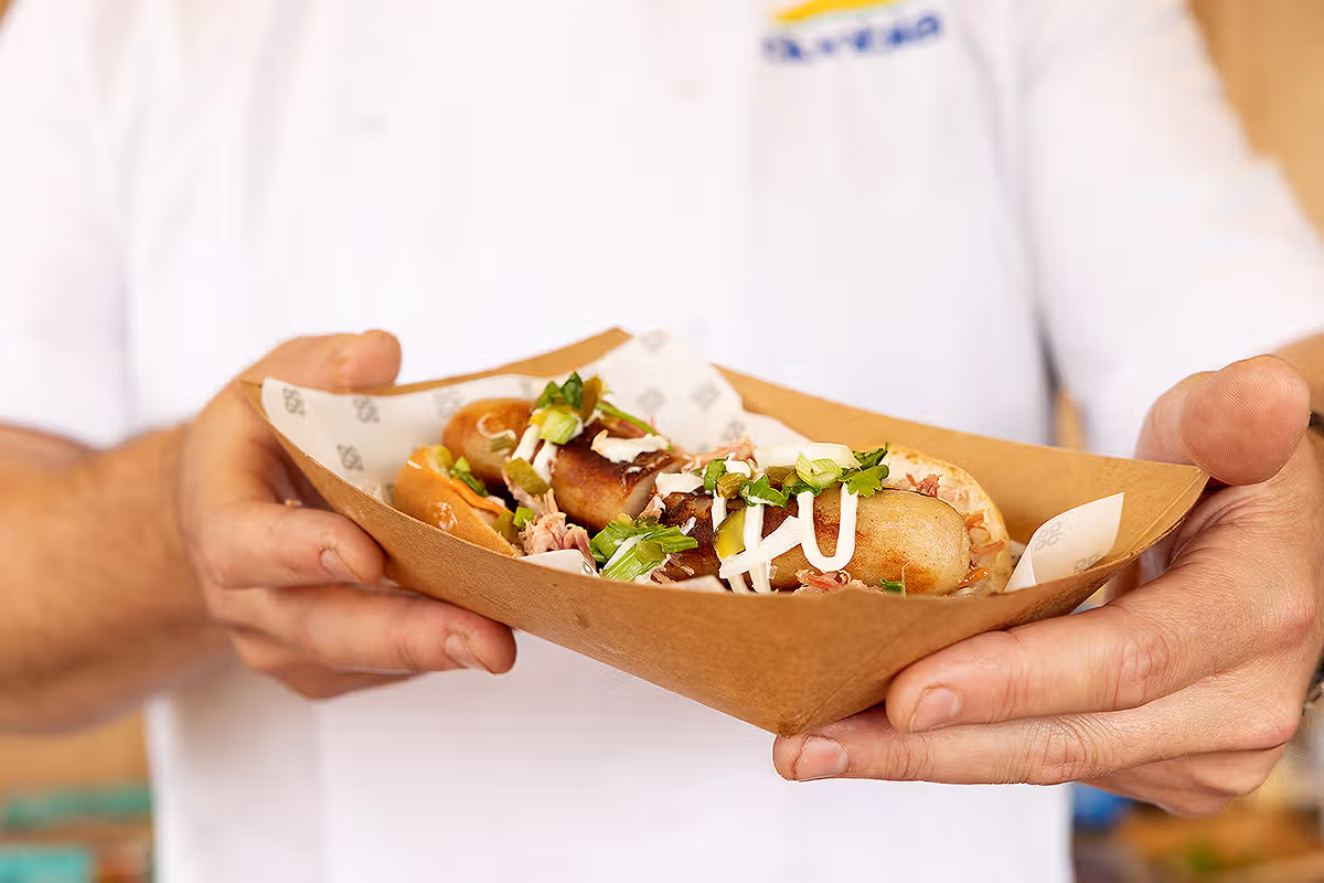 Food PR photograph showing a Co-op Food Festival hot dog served in branded paper during the London activation