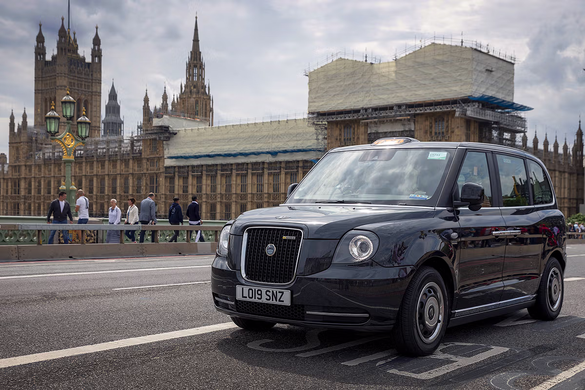 LEVC electric London taxi on Westminster Bridge with the Houses of Parliament behind
